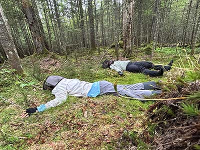 Researchers lying down in soft moss bed