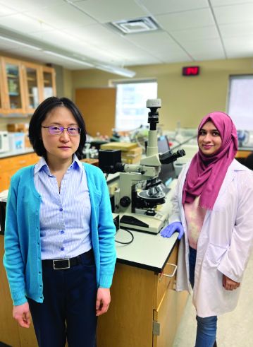 Two international students standing in a laboratory.