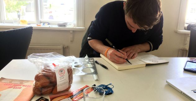 Student hunched over a journal, writing