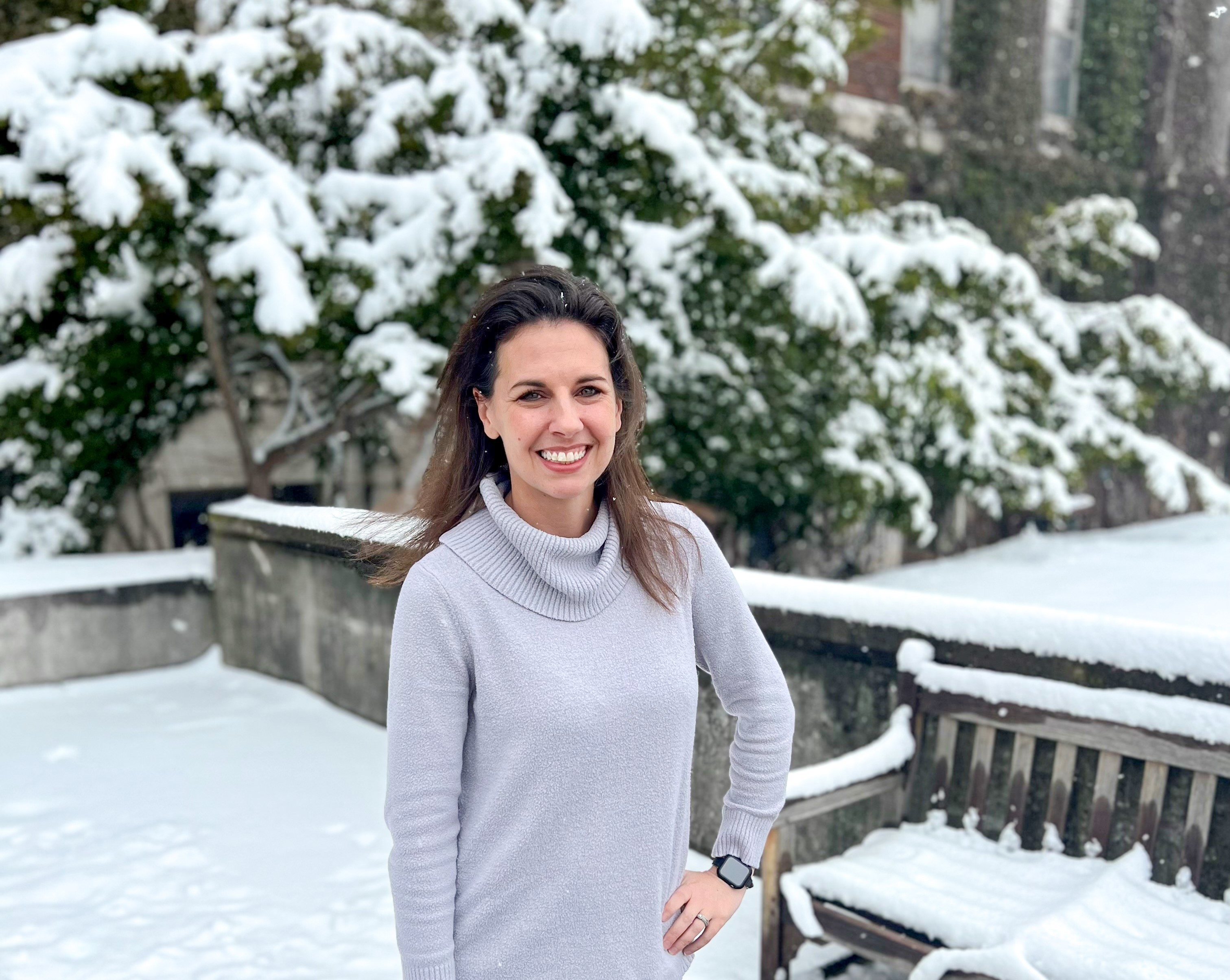 Woman standing with a snowy background.