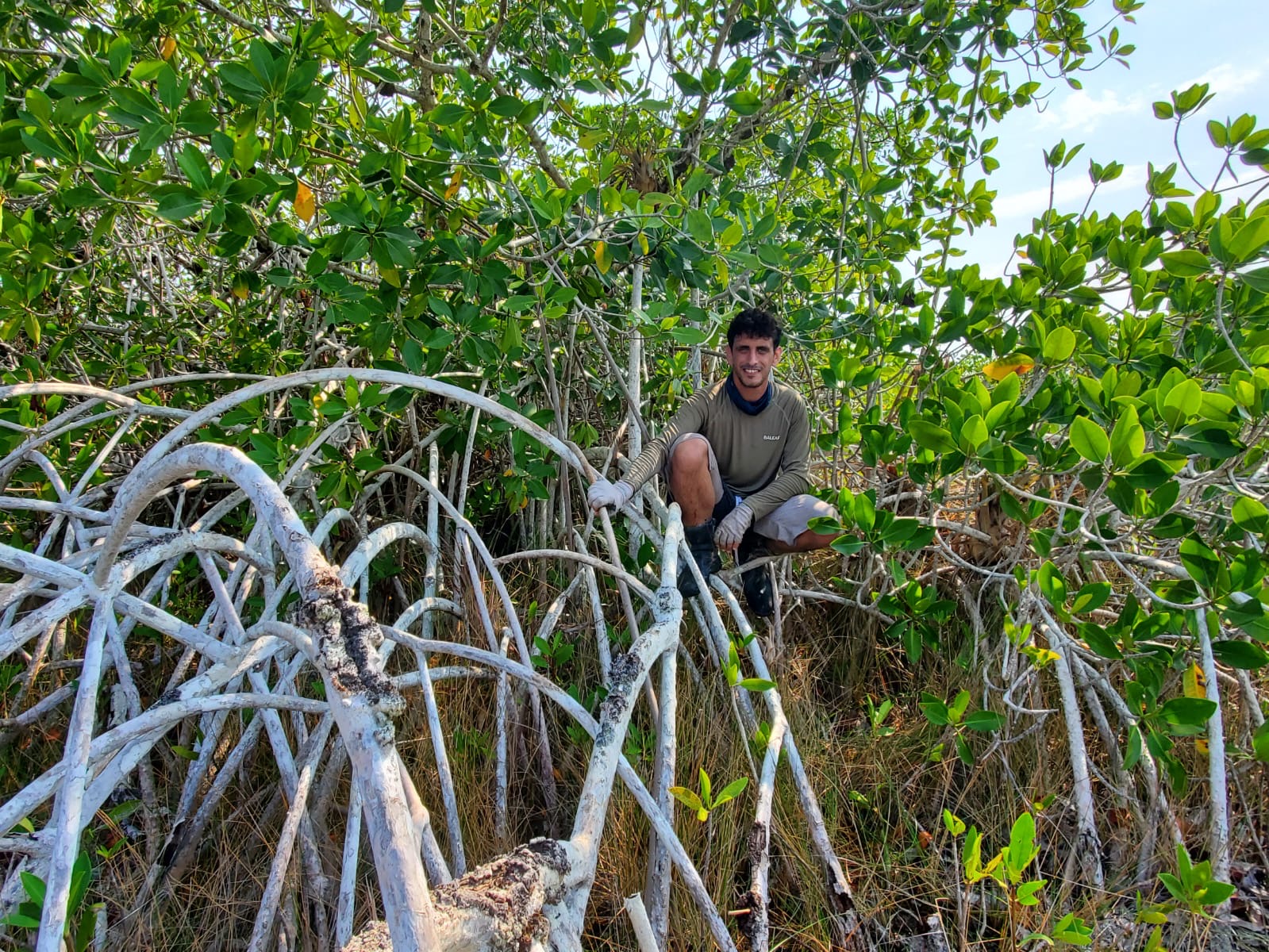 Student Zach Mills posing with a tree in Bacalar, Mexico