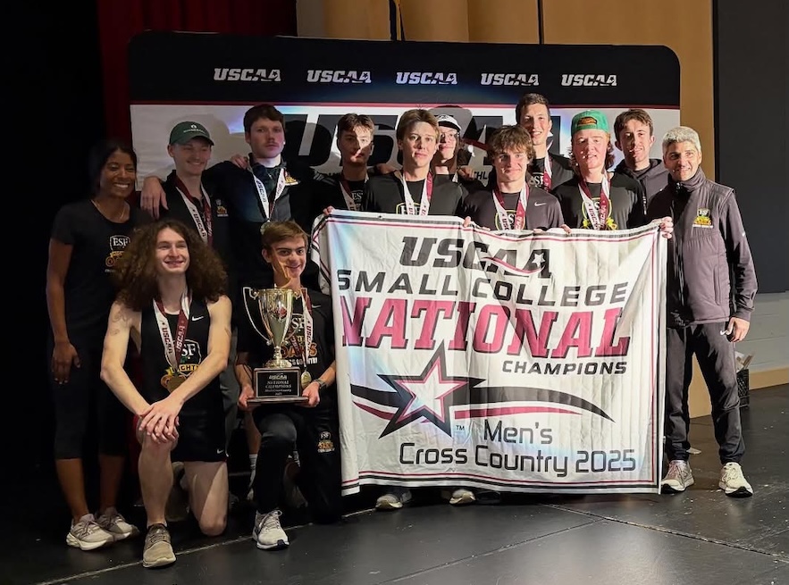 Mens Cross Country team poses with their championship banner.