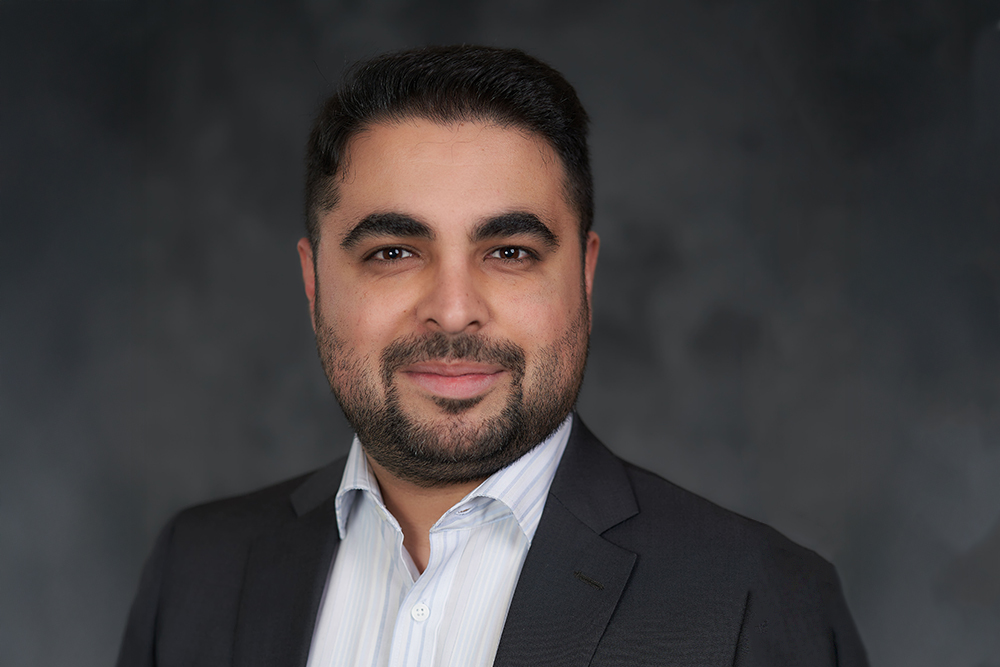 Man with dark hair, moustache and beard wearing dark suit jacket over a white shirt.