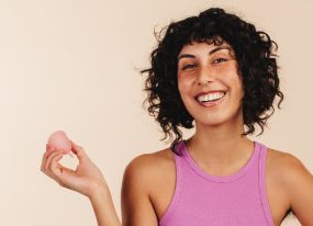 Woman holding a reusable menstrual cup.