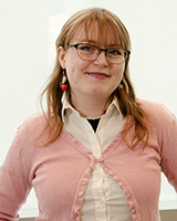 Rowan Stout wearing glasses and a pink sweater